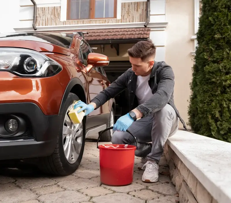 Lavage auto à domicile Dommartin : professionnel intervenant sur un véhicule